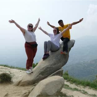 Challenges Abroad team members posing sitting on a rock