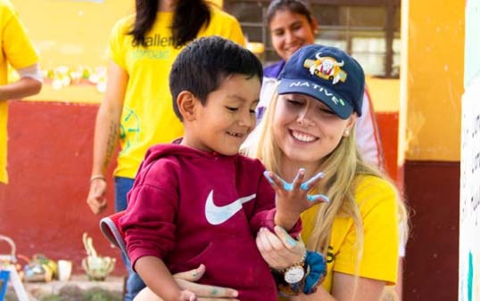 Challenges Abroad team member looking at childs painted hand